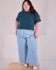 Ashley is wearing Cropped Burly Tee in Lagoon and indigo Wide Leg Denim in Light Wash