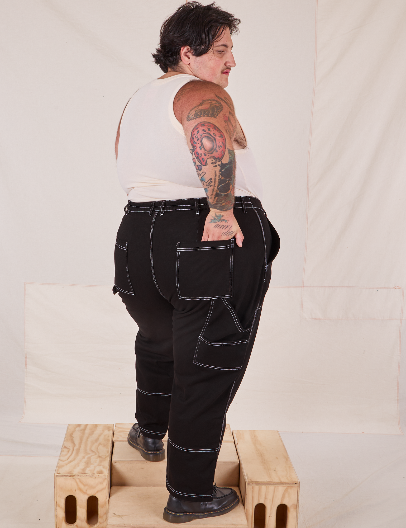 Angled back view of Carpenter Jeans in Black worn by Sam