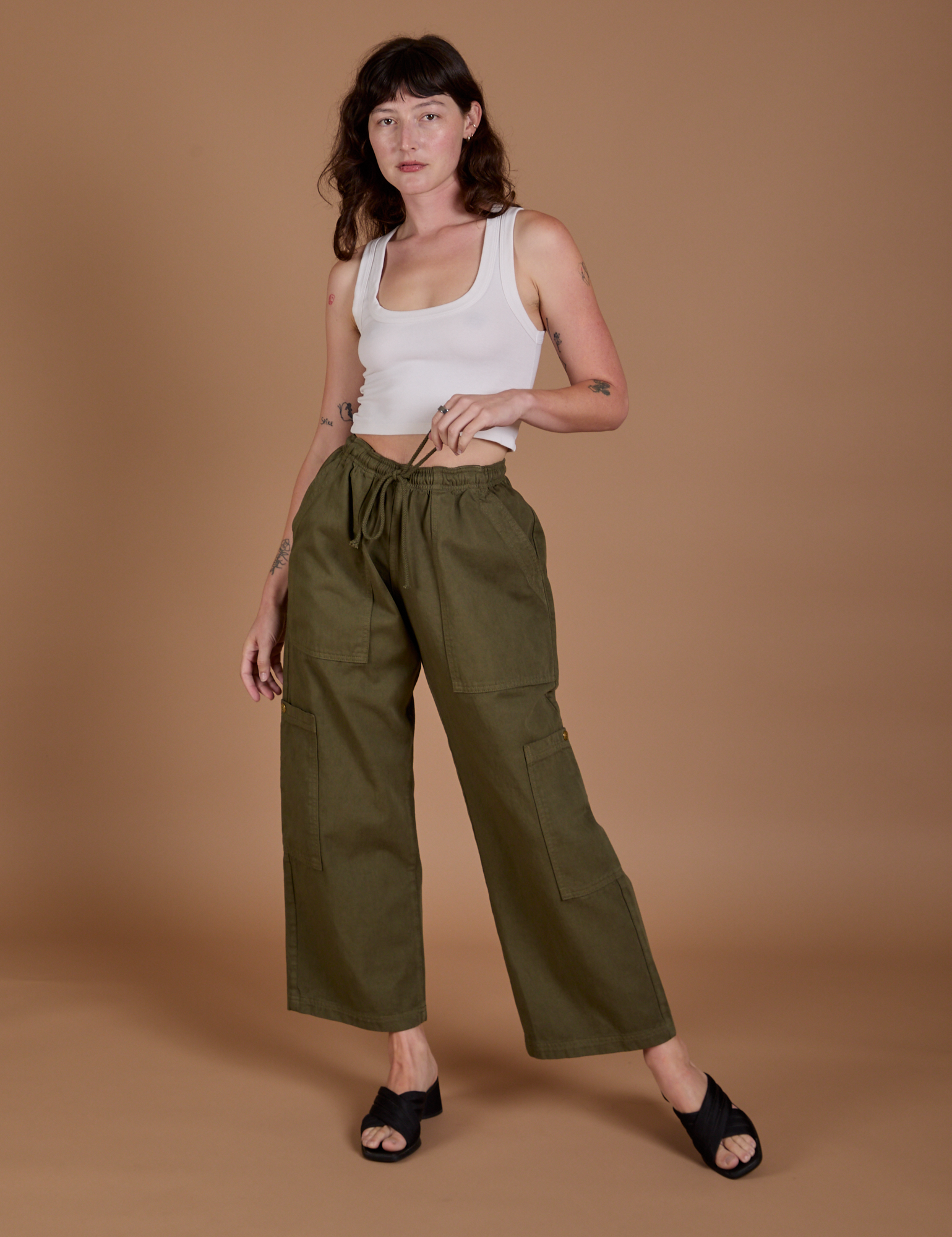 Alex is 5’8” and wearing XXS Drop Pocket Cargo Pants in Surplus Green paired with a Cropped Tank in Vintage Tee White