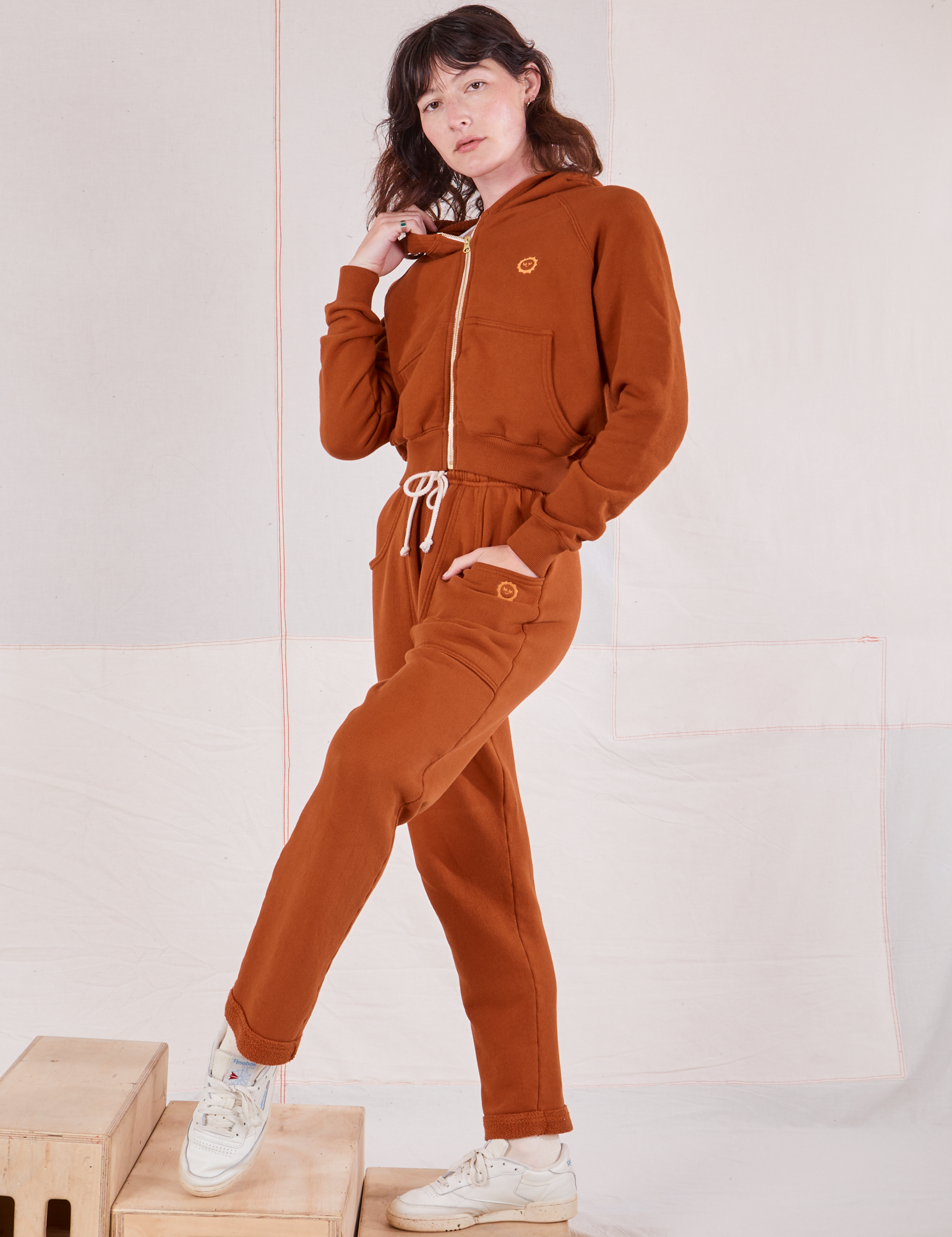 Alex is 5&#39;8&quot; and wearing P Cropped Zip Hoodie in Burnt Terracotta paired with matching Rolled Cuff Sweat Pants