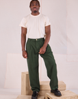 Issac is wearing Heritage Trousers in Swamp Green and Organic Vintage Tee in vintage tee off-white