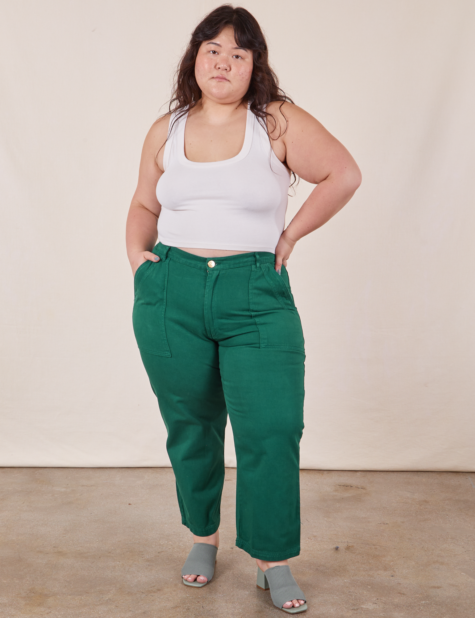 Ashley is 5&#39;7&quot; and wearing 1XL Petite Work Pants in Hunter Green paired with vintage off-white Cropped Tank Top