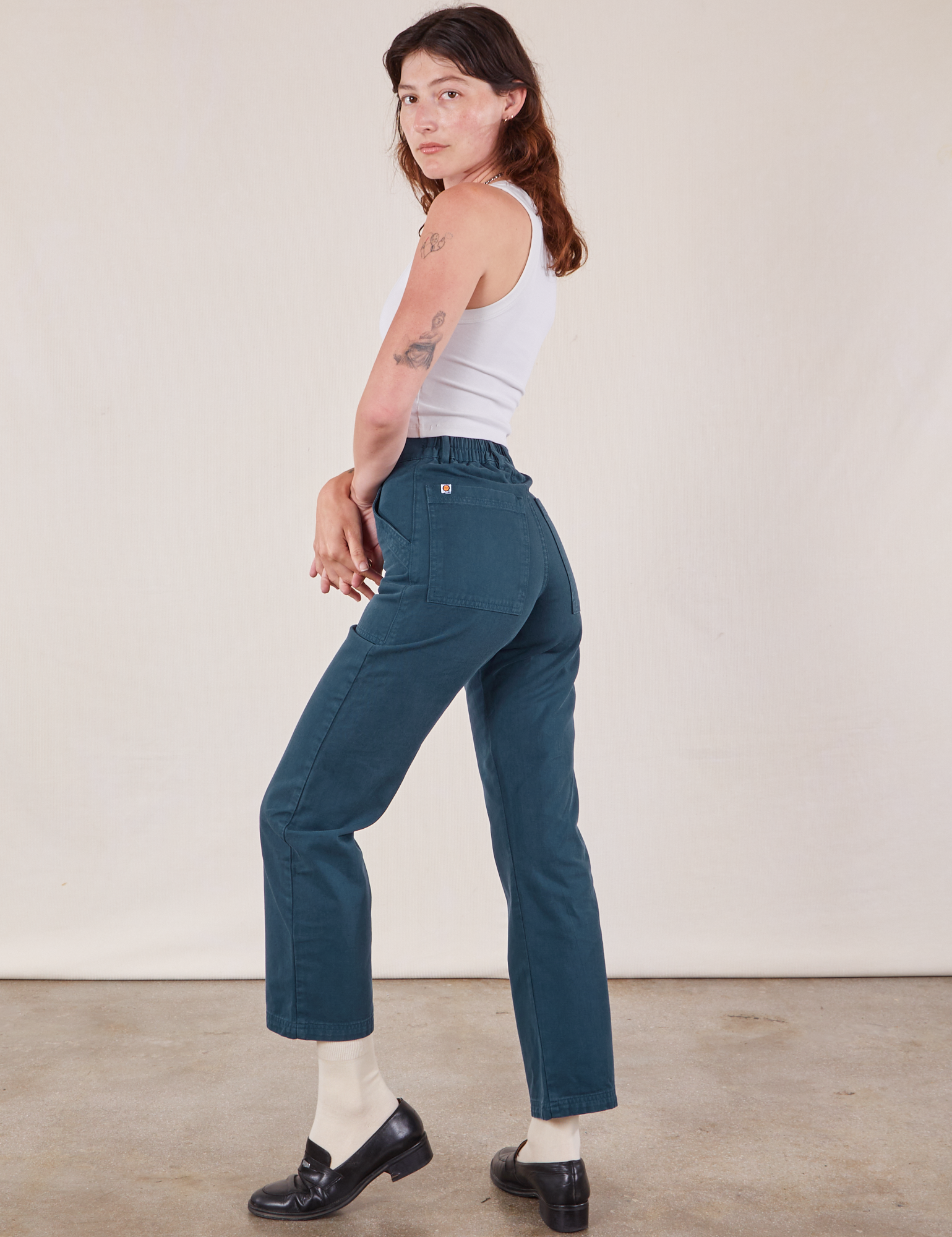 Angled back view of Work Pants in Lagoon and vintage tee off-white Cropped Tank on Alex