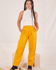 Gabi is 5'7" and wearing XXS Organic Trousers in Mustard Yellow paired with Sleeveless Turtleneck in vintage tee off-white