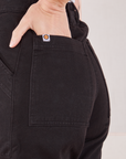 Organic Work Pants in Basic Black back pocket close up. Alex has her hand in the pocket.