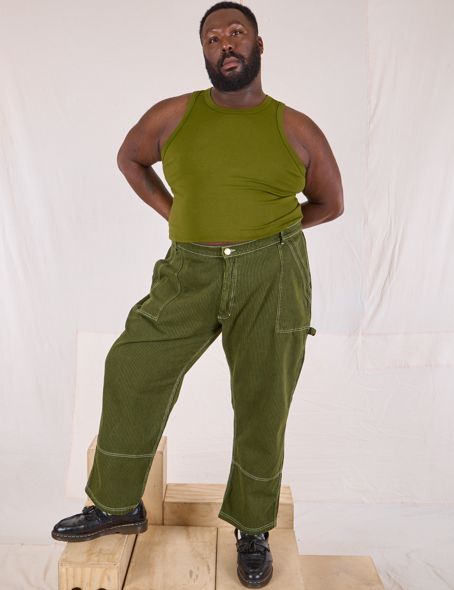 Elijah is 6’4” and wearing 3XL Railroad Carpenter Jeans in Summer Olive paired with a summer olive Muscle Tee