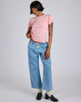 Kira is wearing Jr. Varsity Tee in Baby Pink and light wash Denim Drop Pocket Pants