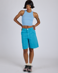 Kira is wearing Longline Work Shorts in Hawaiian Blue and baby blue Racerback Tank