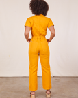 Back view of Short Sleeve Jumpsuit in Mustard Yellow worn by Gabi