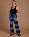 Angled front view of Black Stripe Work Pants in Cornflower Blue and black Cropped Tank on Tiara