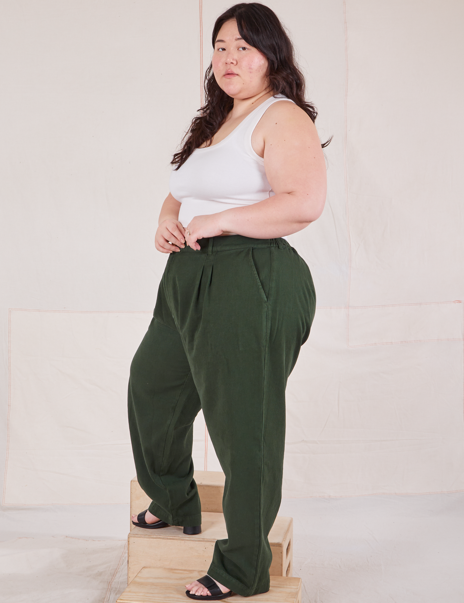 Side view of Heritage Trousers in Swamp Green and Cropped Tank Top in vintage tee off-white on Ashley