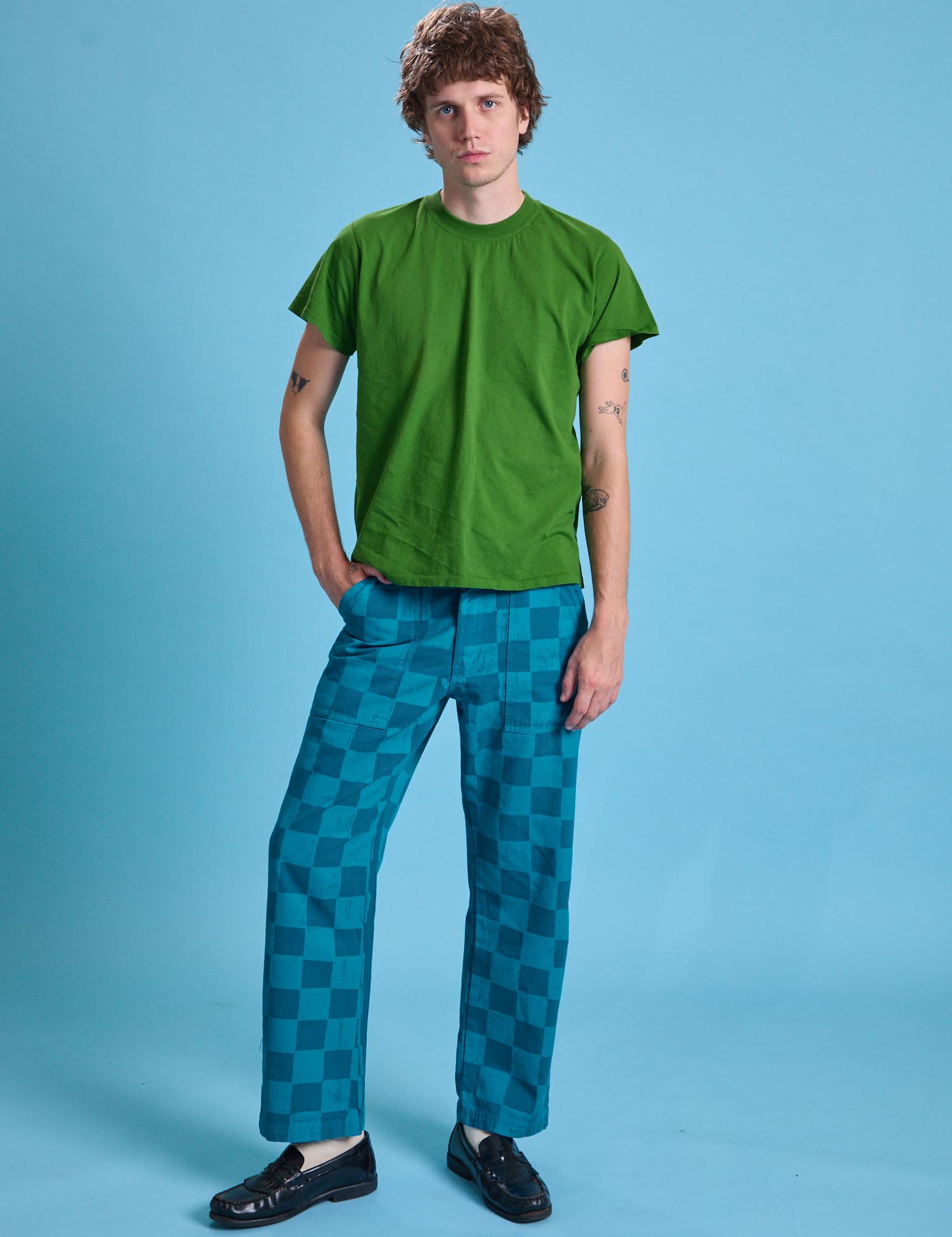 Quinn is 6'3" and wearing M Checkerboard Work Pants in Blues paired with lawn green Organic Vintage Tee