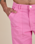 Close up of Jesse's hand in the front pocket of Work Pants in Bubblegum Pink