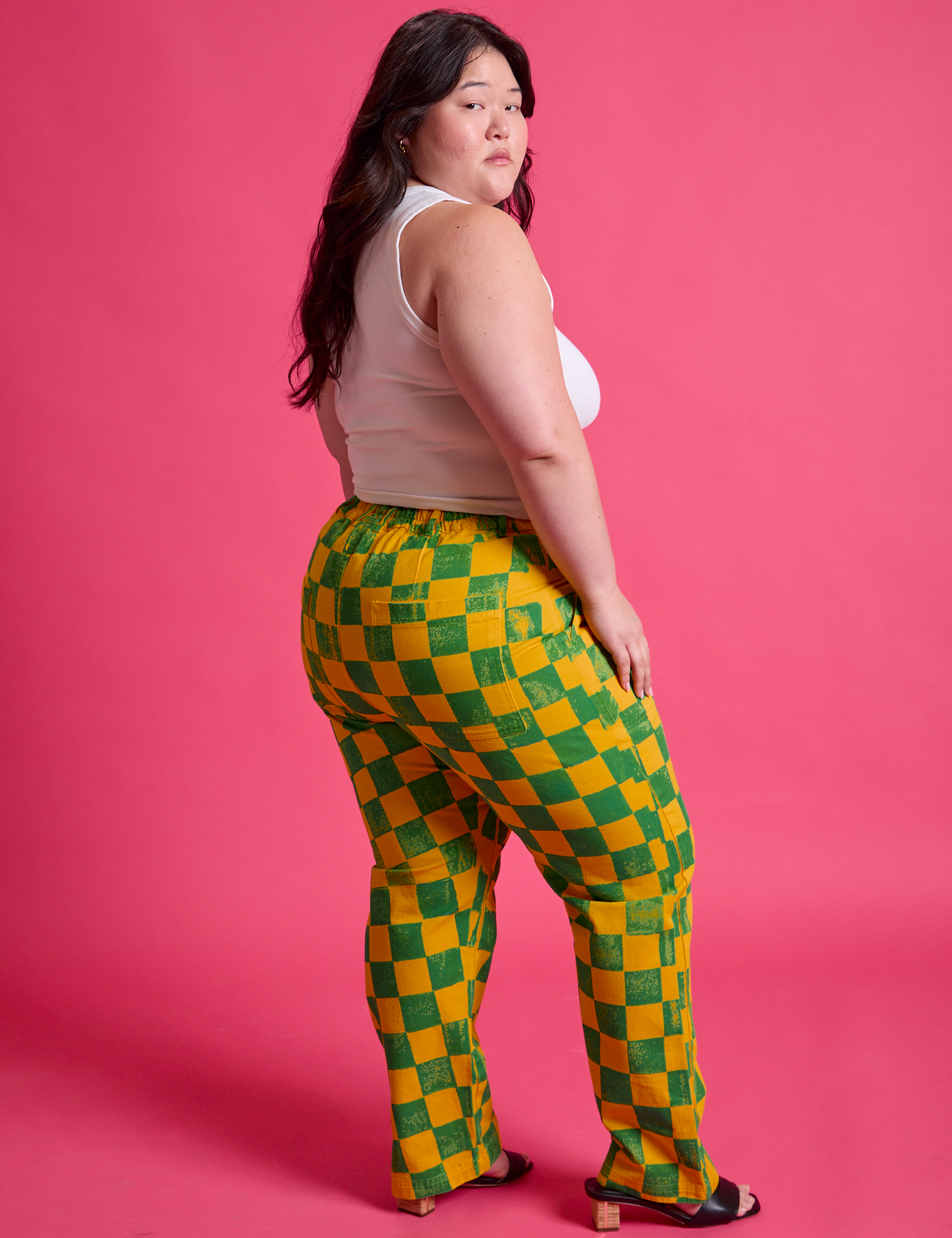 Angled back view of Checkerboard Work Pants in Green/Yellow and Cropped Tank in Vintage Tee White