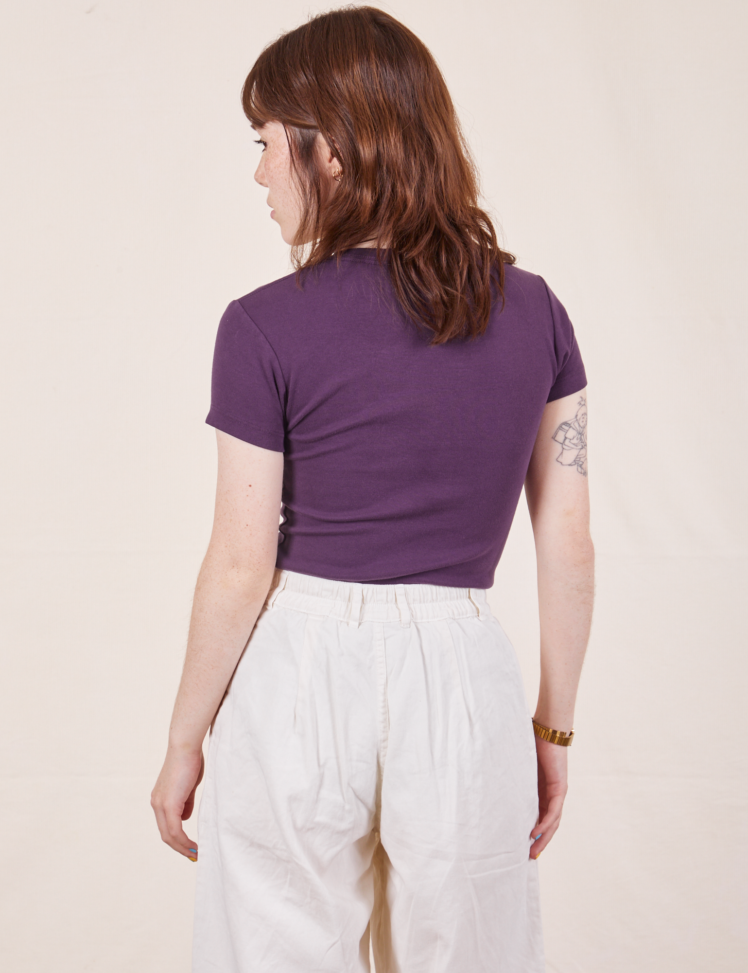 Back view of Baby Tee in Nebula Purple and vintage off-white Trousers worn by Hana