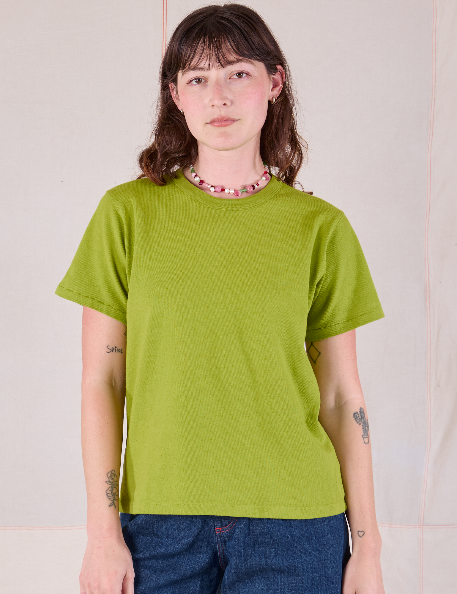 Alex is 5'8" and wearing P Burly Tee in Gross Green