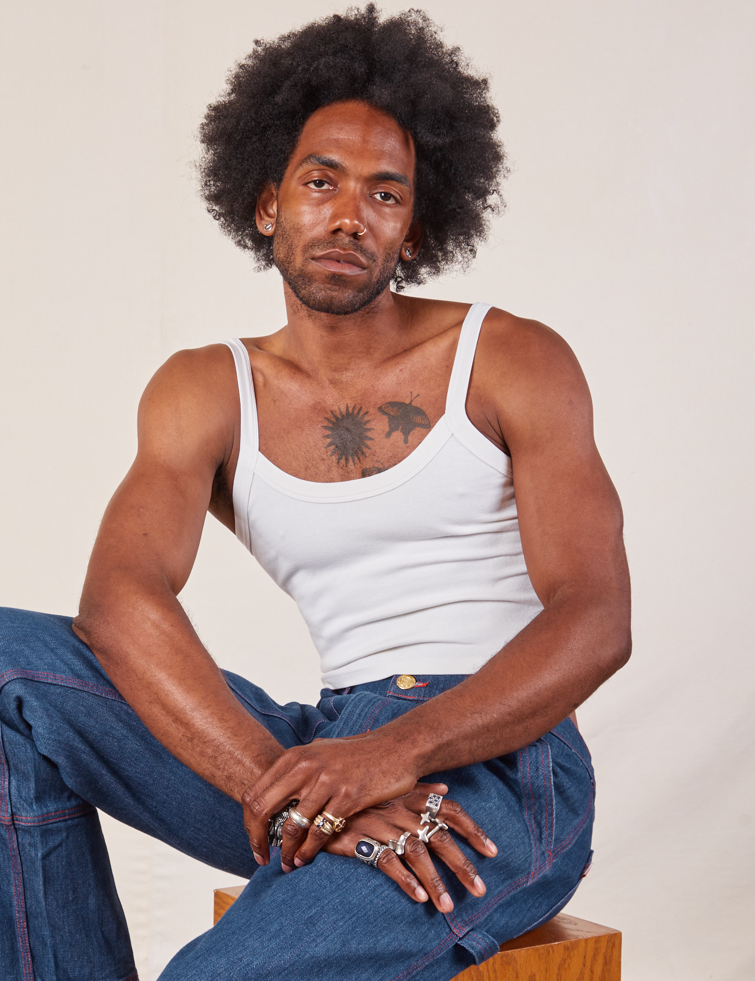Jerrod is wearing Cropped Cami in Vintage Tee Off-White and dark wash Carpenter Jeans
