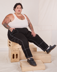 Sam is wearing Carpenter Jeans in Black and Tank Top in vintage tee off-white