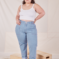 Ashley is 5'7" and wearing 1XL Carpenter Jeans in Light Wash paired with vintage off-white Cropped Cami