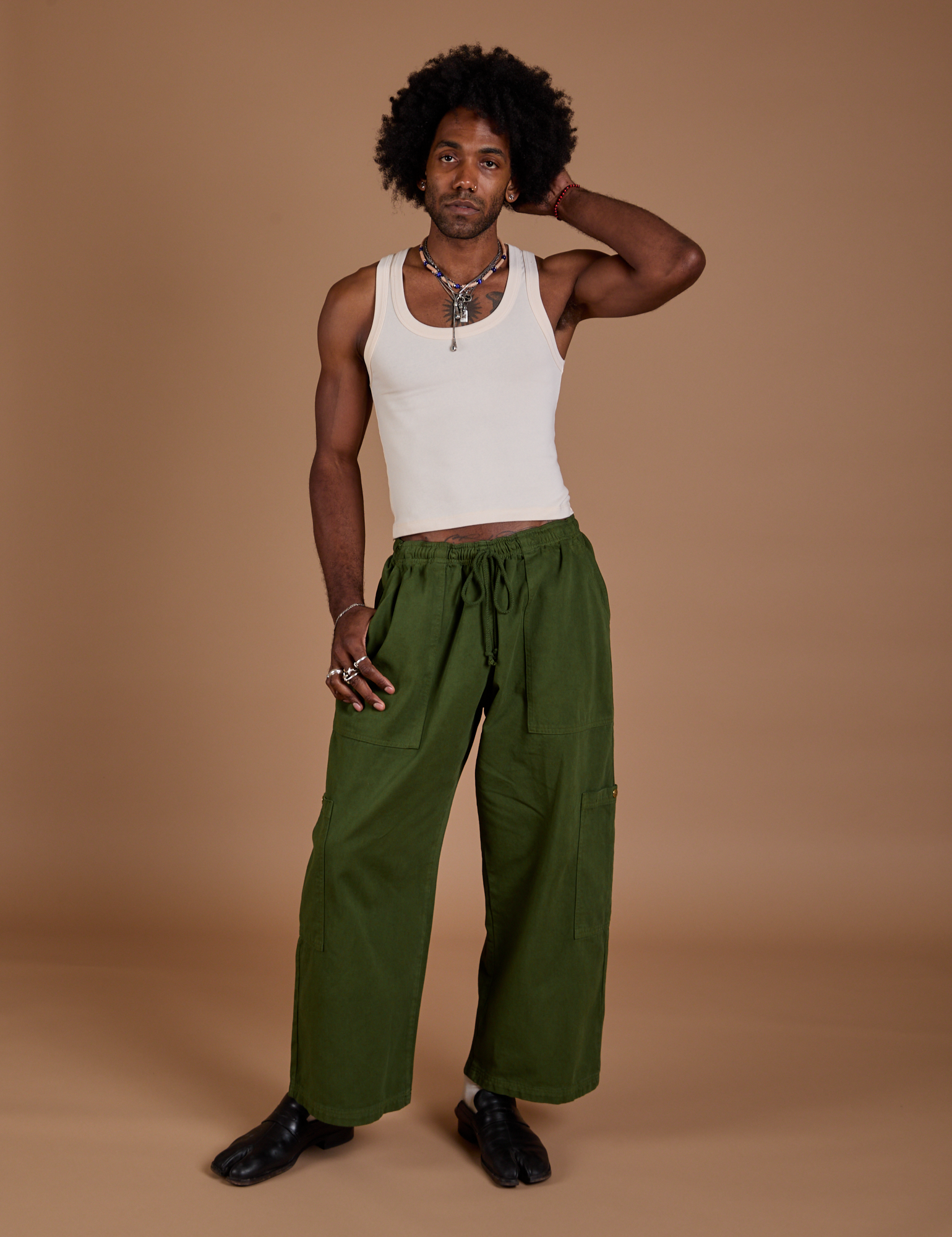 Jerrod is 6’3” and wearing M Drop Pocket Cargo Pants in Evergreen paired with a Tank Top in vintage tee white