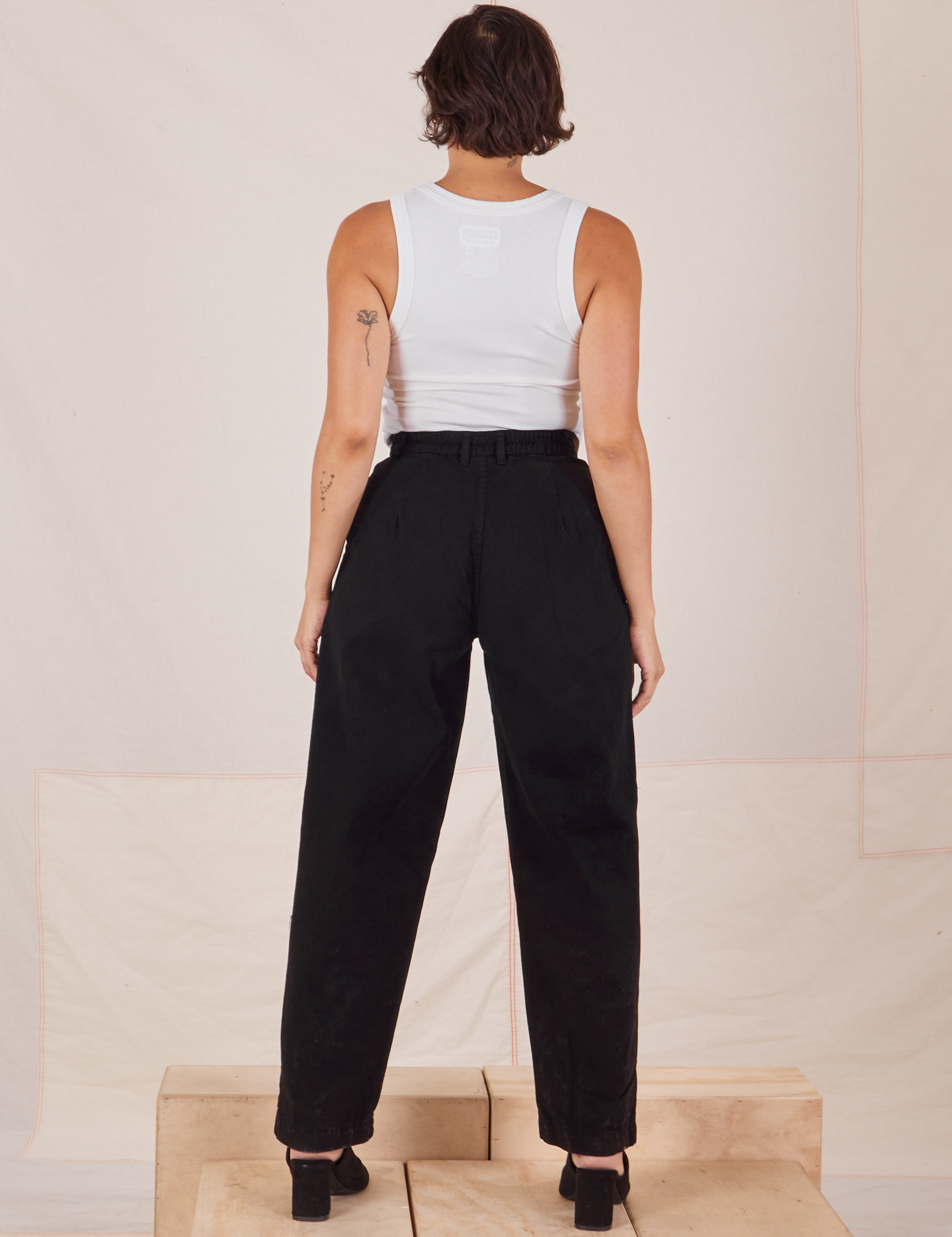 Back view of Heavyweight Trousers in Basic Black and Cropped Tank Top in vintage tee off-white worn by Tiara