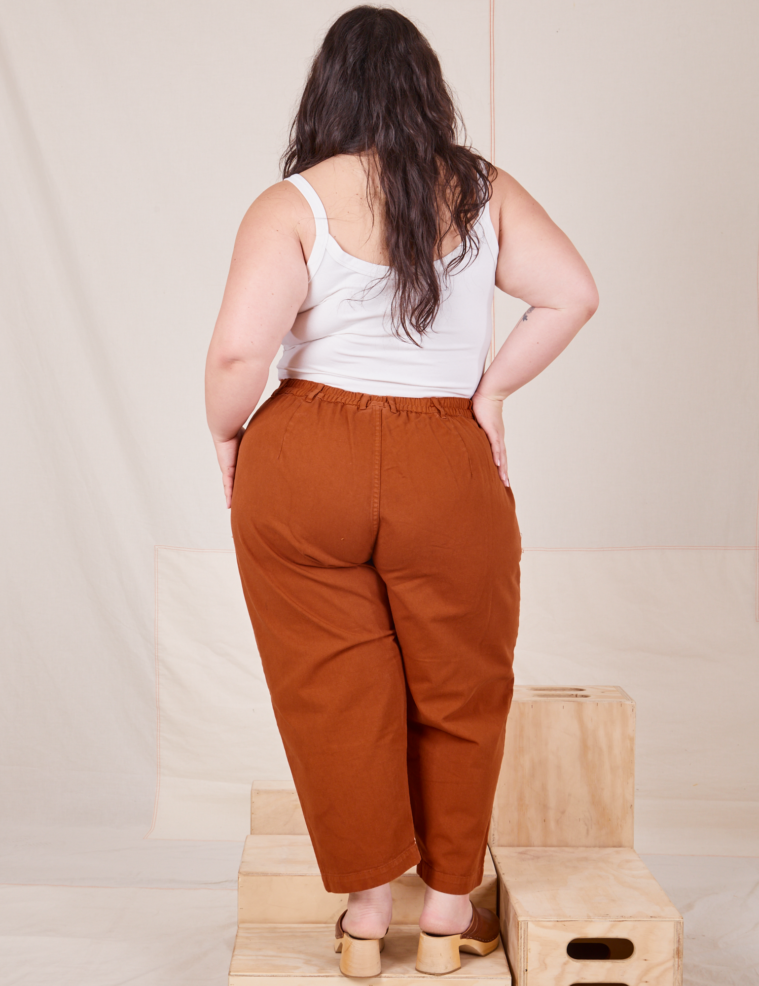 Back view of Heavyweight Trousers in Burnt Terracotta and Cropped Cami in vintage tee off-white worn by Ashley