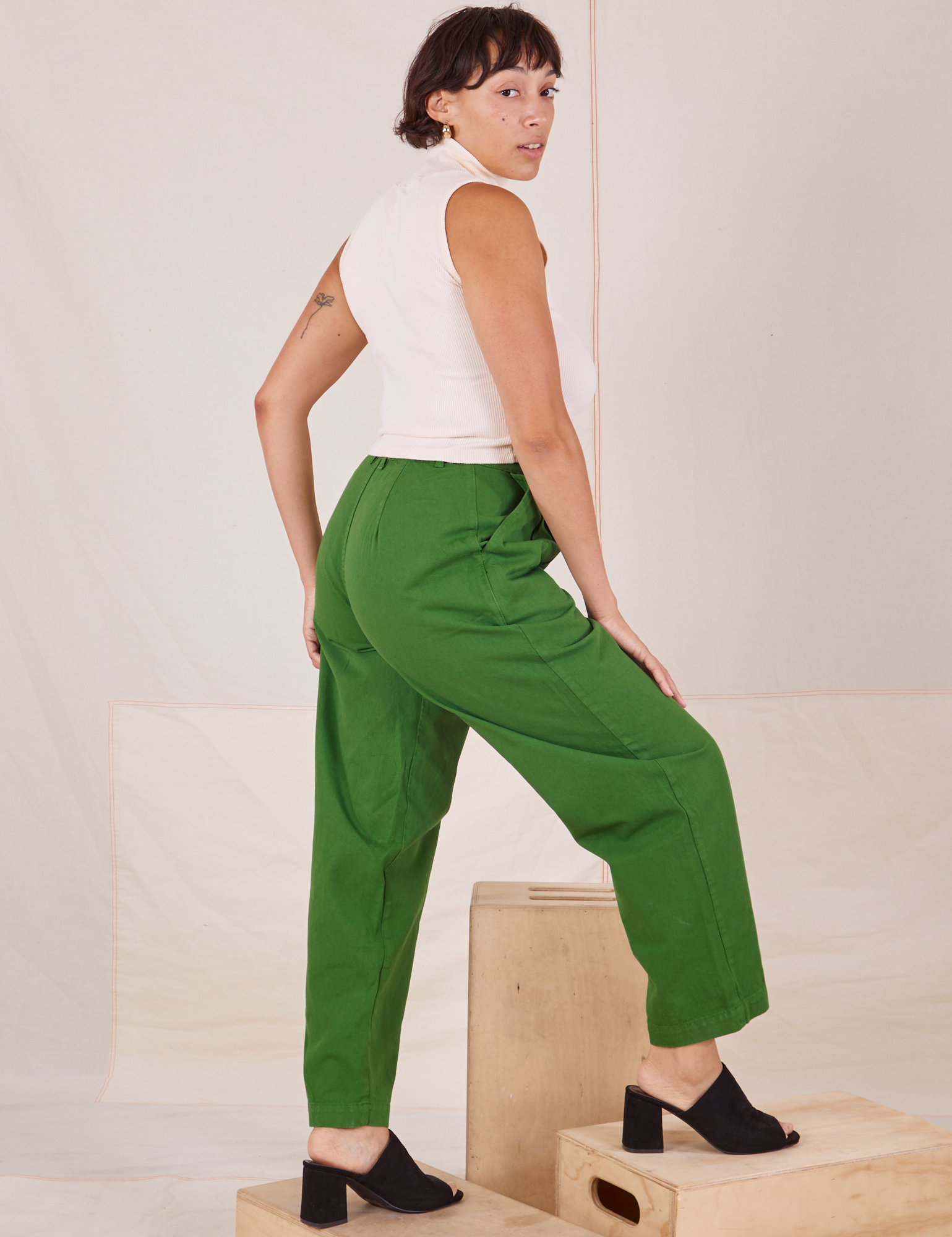 Angled back view of Heavyweight Trousers in Lawn Green and Sleeveless Turtleneck in vintage tee off-white worn by Tiara