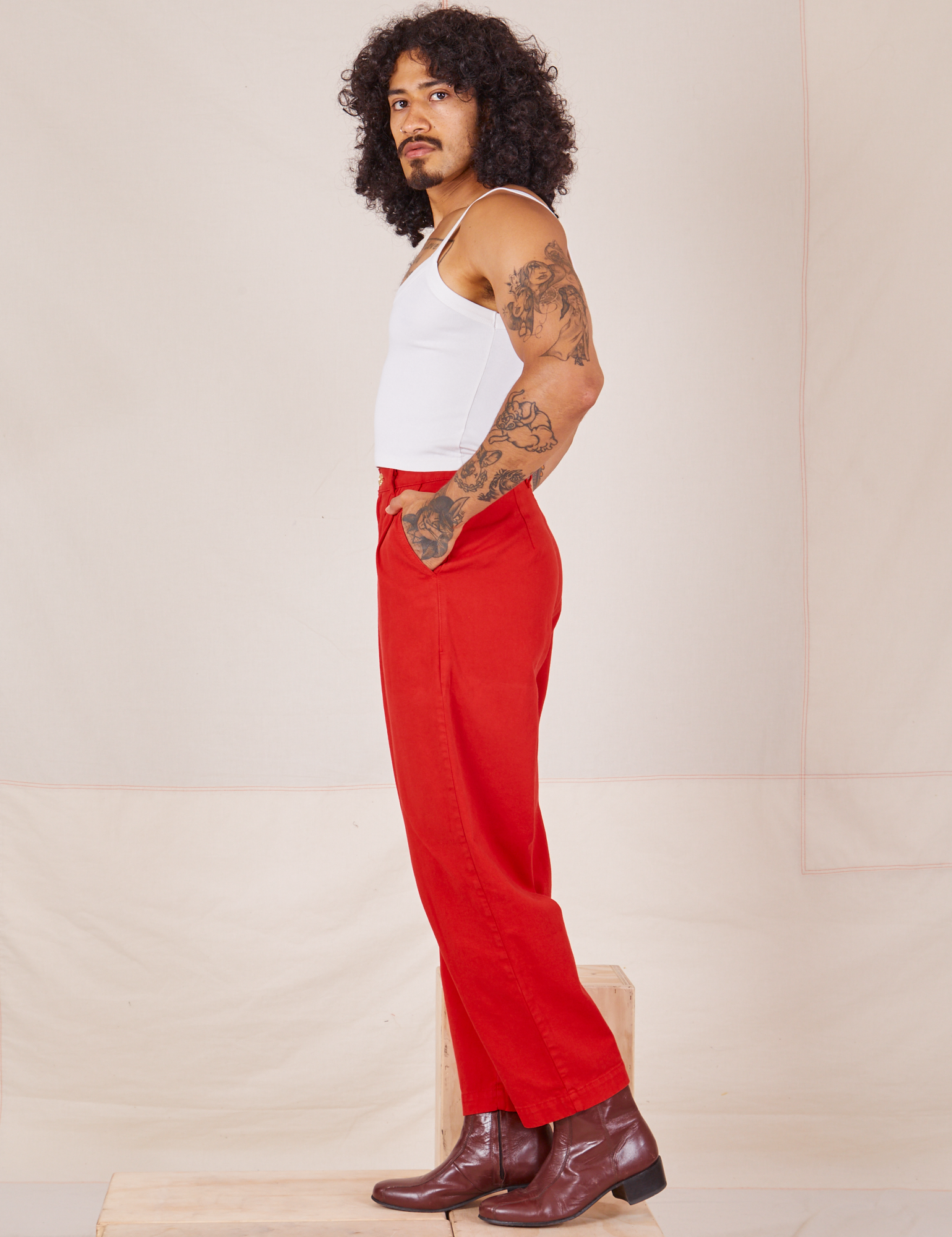 Side view of Heavyweight Trousers in Mustang Red and Cropped Cami in vintage tee off-white worn by Jesse