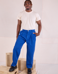 Issac is wearing Heritage Trousers in Royal Blue and tucked in Organic Vintage Tee in vintage tee off-white