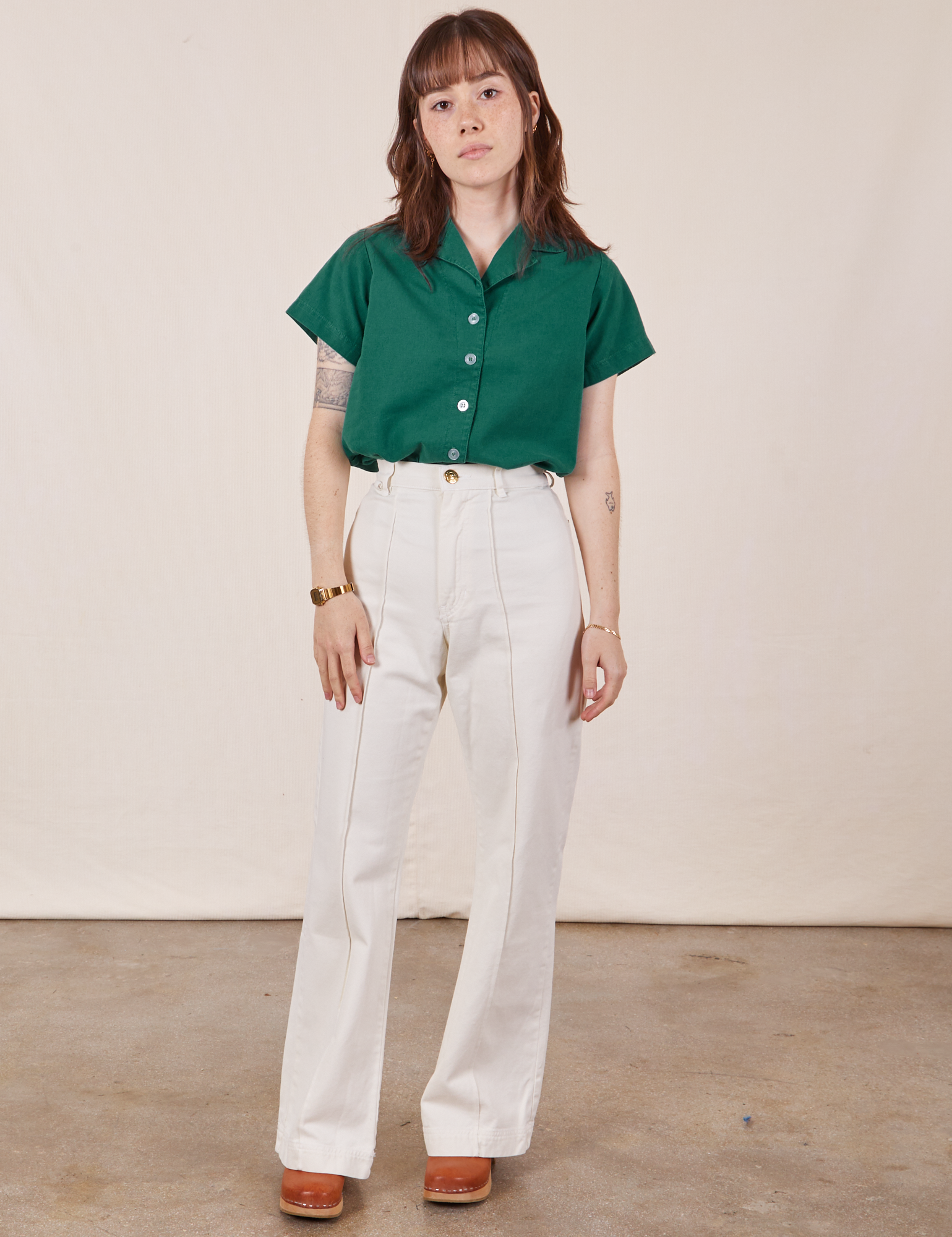 Hana is wearing Pantry Button-Up in Hunter Green tucked into vintage tee off-white Petite Western Pants