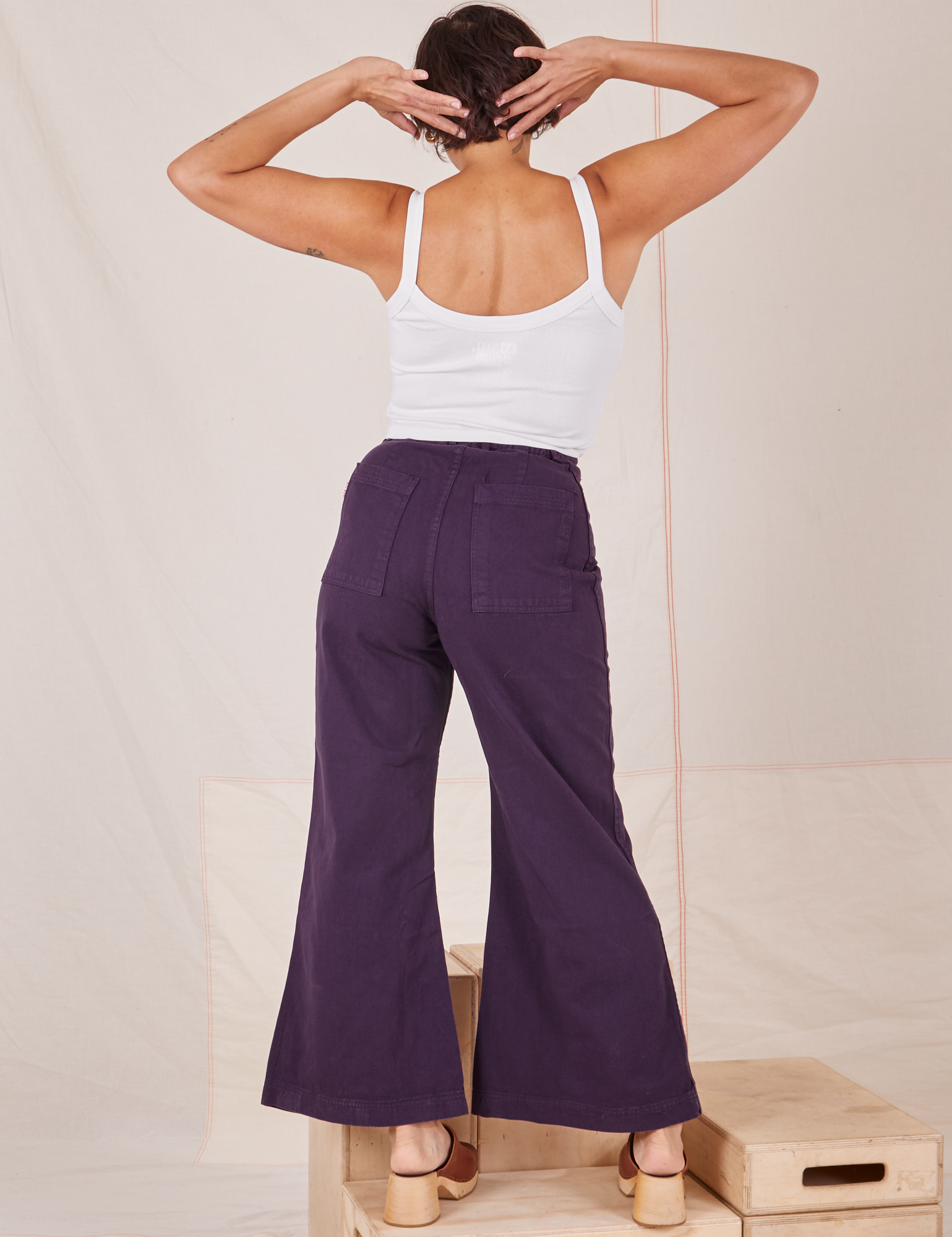 Back view of Bell Bottoms in Nebula Purple and Cropped Cami in vintage tee off-white worn by Tiara