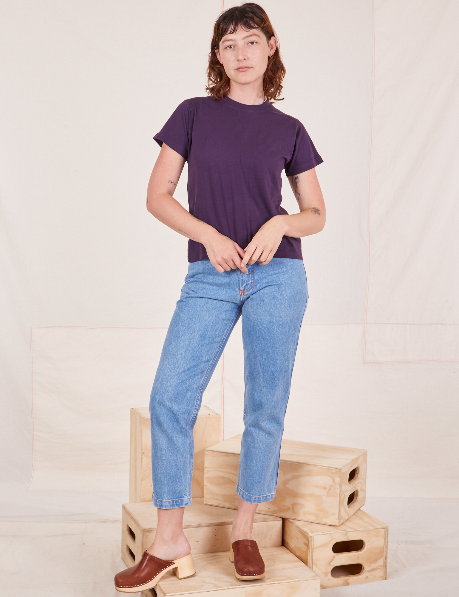 Alex is wearing The Organic Vintage Tee in Nebula Purple and light wash Frontier Jeans