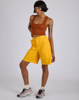 Angled front view of Longline Work Shorts in Sunshine Yellow and burnt terracotta Cropped Tank