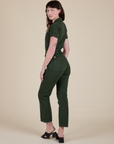 Angled back view of Short Sleeve Jumpsuit in Swamp Green on Alex