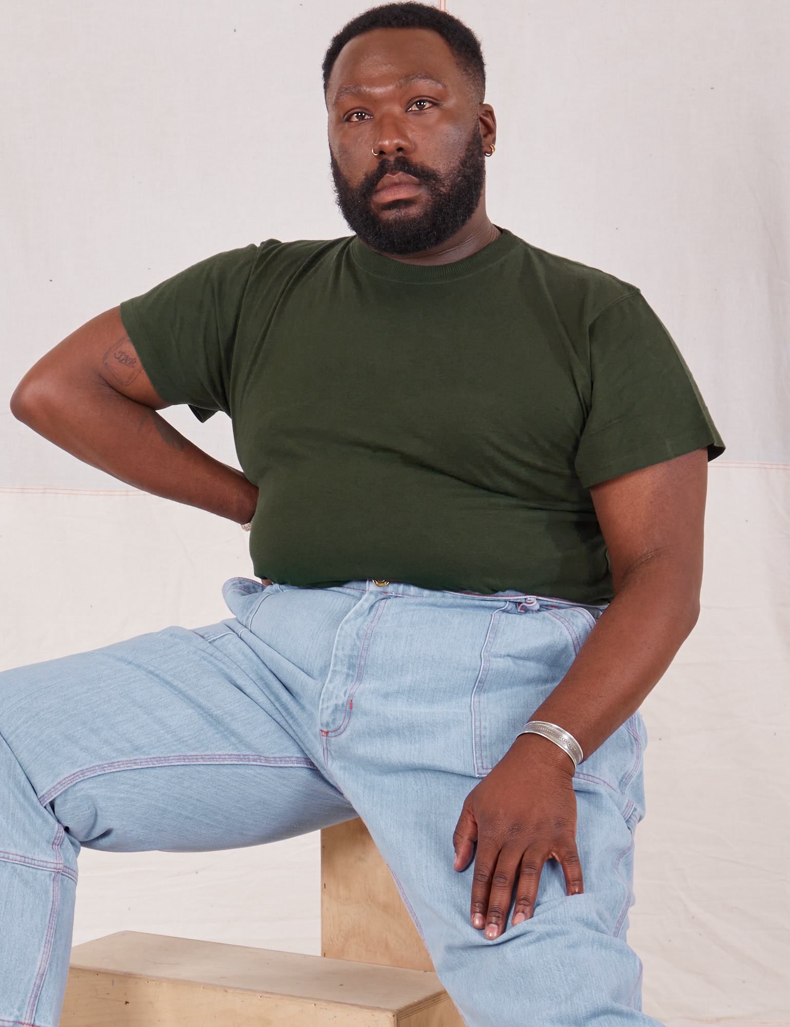 Elijah is wearing Organic Vintage Tee in Swamp Green and light wash Carpenter Jeans