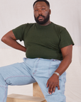 Elijah is wearing Organic Vintage Tee in Swamp Green and light wash Carpenter Jeans