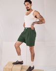 Side view of Trouser Shorts in Swamp Green and Tank Top in vintage tee off-white on Jesse