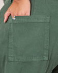 Back pocket close up of Western Pants in Dark Green Emerald. Alicia has her hand in the pocket.
