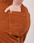 Classic Work Shorts in Burnt Terracotta back pocket close up. Ashley has her hand in the pocket.