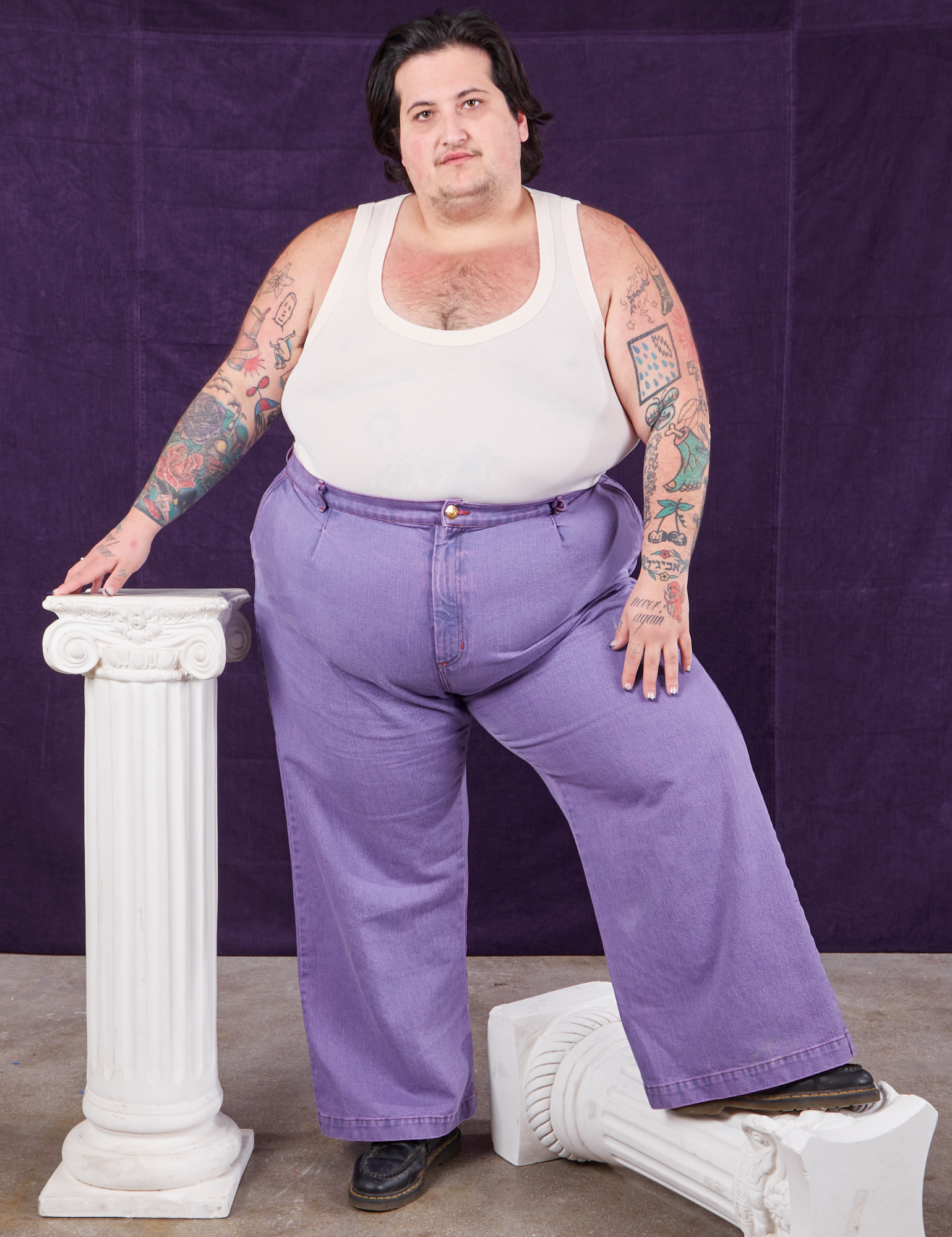 Sam is wearing Overdyed Wide Leg Trousers in Faded Grape and Tank Top in vintage tee off-white