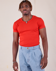 Isaac is wearing Baby Tee in Mustang Red tucked into light wash Denim Trousers