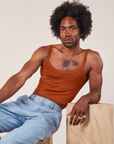 Jerrod is wearing Cropped Cami in Burnt Terracotta and light wash Carpenter Jeans