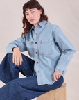 Alex is wearing a buttoned up Denim Overshirt in Light Wash