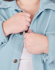 Front close up of Flannel Overshirt in Baby Blue. Marielena is holding the button placket