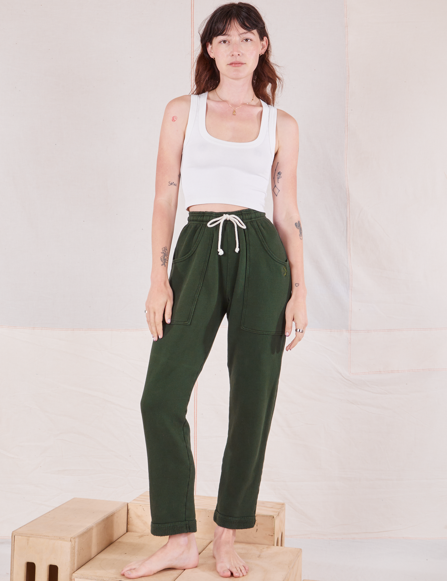 Alex is 5&#39;8&quot; and wearing P Rolled Cuff Sweat Pants in Swamp Green paired with vintage off-white Cropped Tank Top