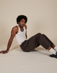 Jerrod is wearing Heavyweight Trousers in Espresso Brown and Tank Top in Vintage Tee Off-White