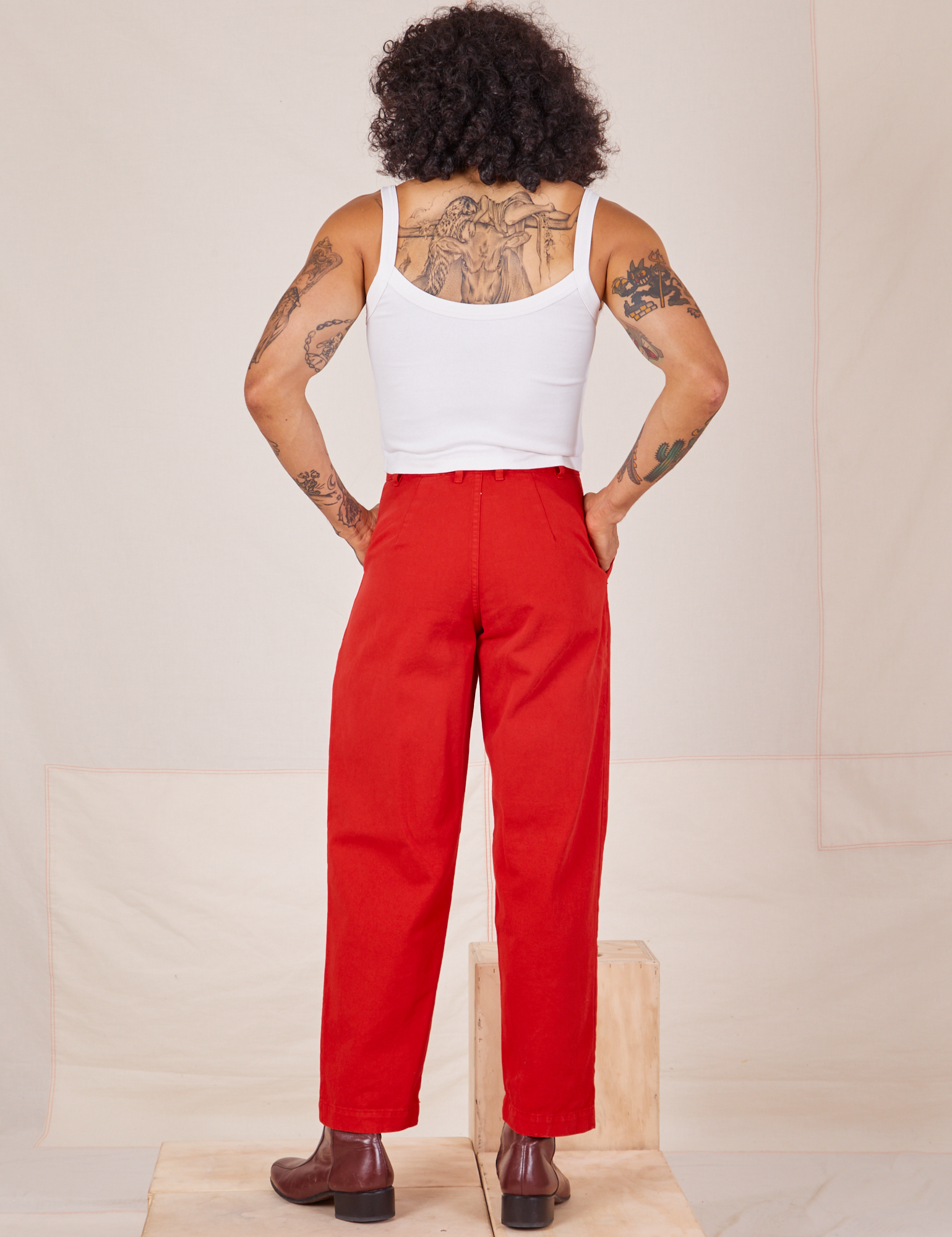 Back view of Heavyweight Trousers in Mustang Red and Cropped Cami in vintage tee off-white worn by Jesse
