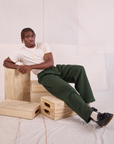 Issac is wearing Heritage Trousers in Swamp Green and Organic Vintage Tee in vintage tee off-white
