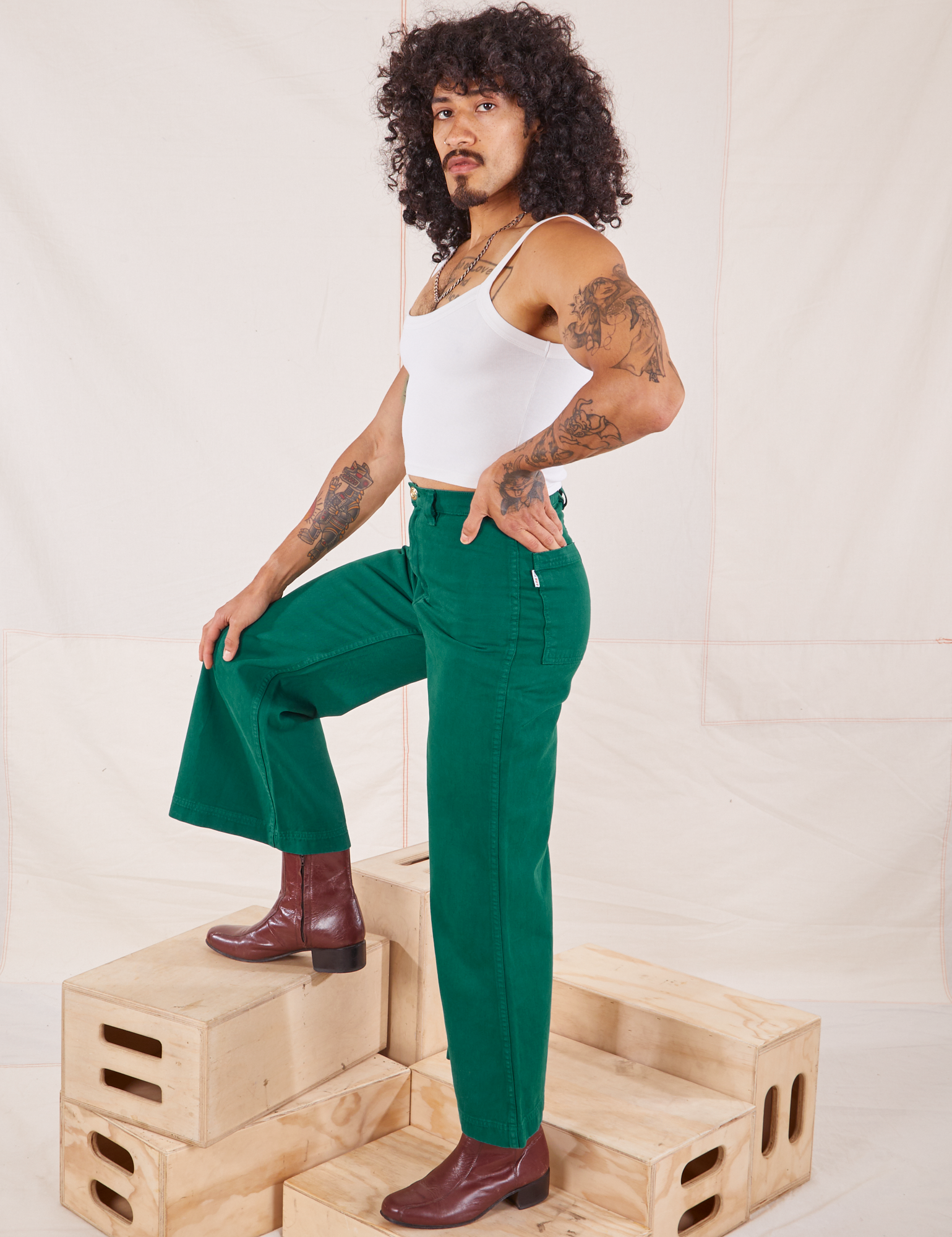 Side view of Bell Bottoms in Hunter Green and Cropped Cami in vintage tee off-white on Jesse