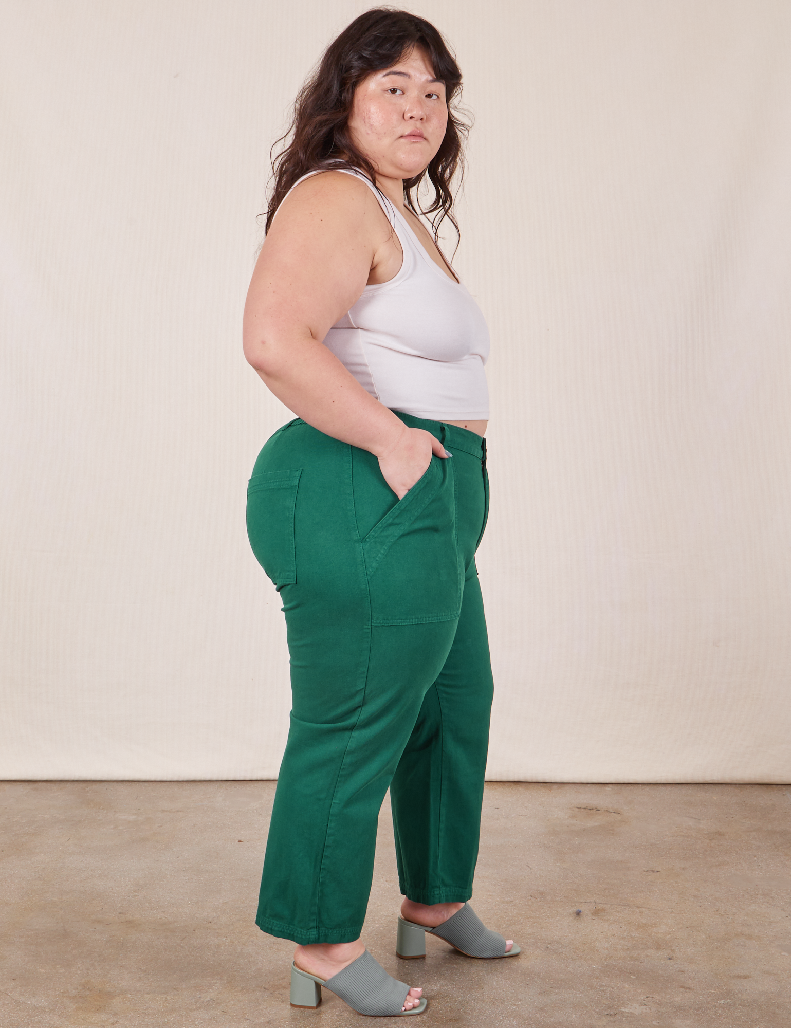 Side view of Work Pants in Hunter Green and Cropped Tank Top in vintage tee off-white worn by Ashley
